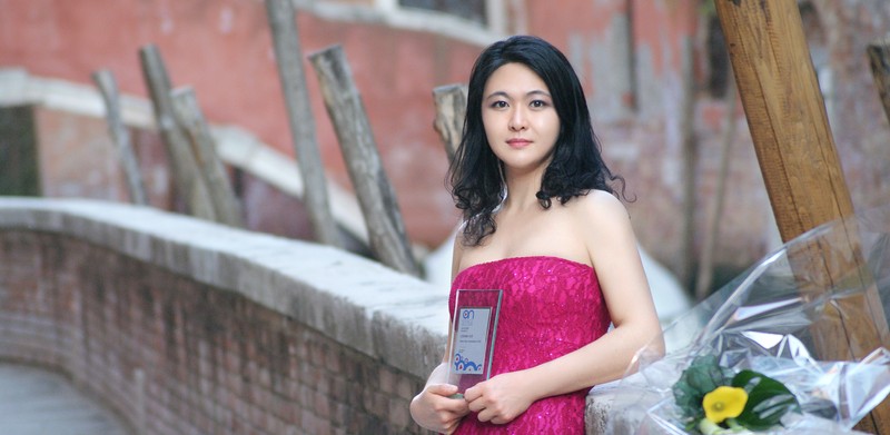Lishan Xue standing in a magenta dress.